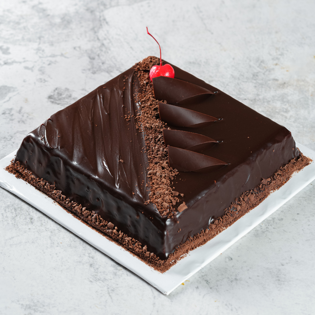 Chocolate ganache cake with a cherry and chocolate curls